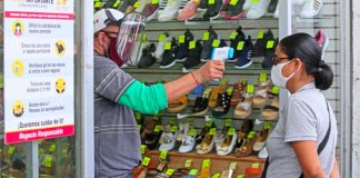 A customer's temperature is checked at a store in Guadalajara in July.