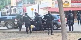Police haul woman from her car in Culiacán on Thursday.