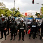 Police prevent access to a Columbus statue in Buenavista, Mexico City.