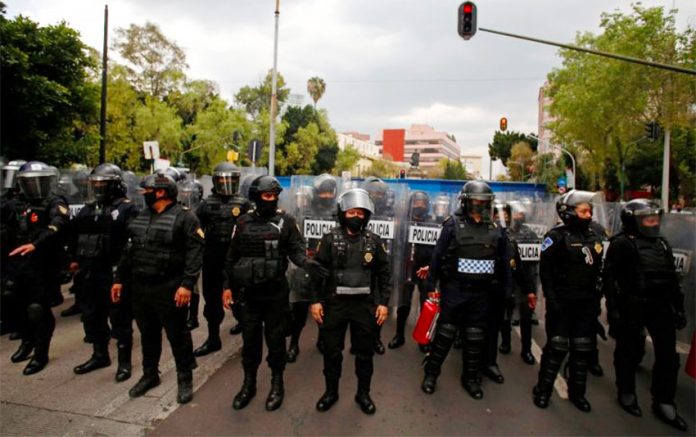 Police prevent access to a Columbus statue in Buenavista, Mexico City.