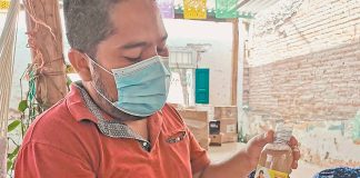 Joel Luis and a bottle of sauce made by El Típico in Ixtepec.
