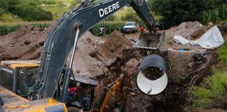Rescue workers and machinery at the site of the collapsed well.