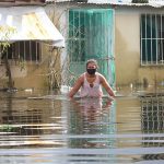 A woman ventures into a flooded street in Tabasco.