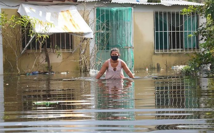 A woman ventures into a flooded street in Tabasco.