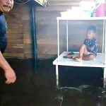 A boy stays dry at a home in José Colomo.