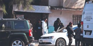 Investigators outside the home where the murders occurred.