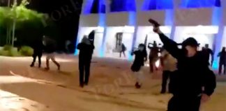 An officer fires his gun during Monday's protest.