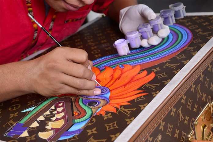 A Zapotec artist at work on a Vuitton trunk.