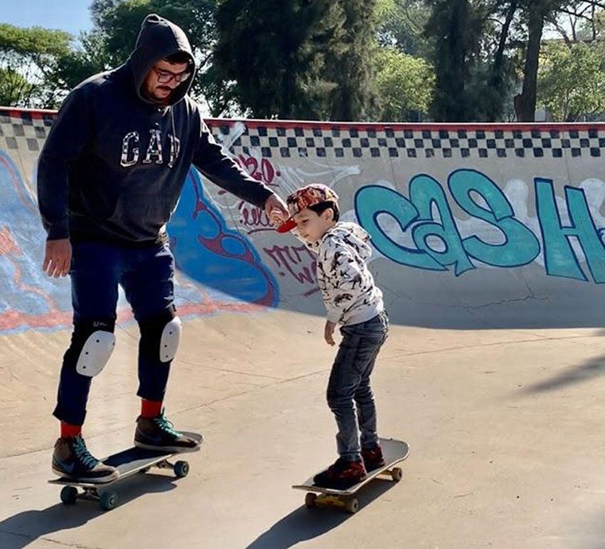 A frequent sight at skateparks: a father teaches his son to skate.