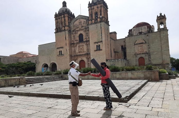 A state official provides hand sanitizer outside the Church of Santo Domingo in Oaxaca city.