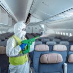 An airline employee sanitizes an airplane before boarding.