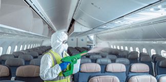 An airline employee sanitizes an airplane before boarding.