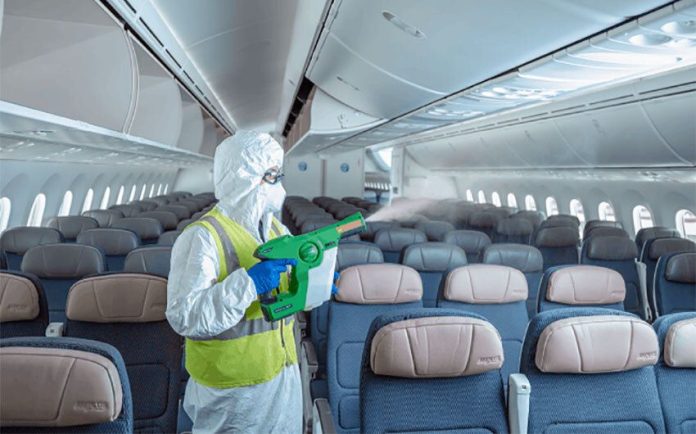 An airline employee sanitizes an airplane before boarding.