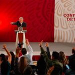 Reporters raise their hands to question the president at his morning press conference.