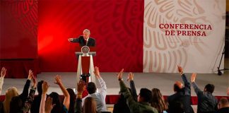 Reporters raise their hands to question the president at his morning press conference.