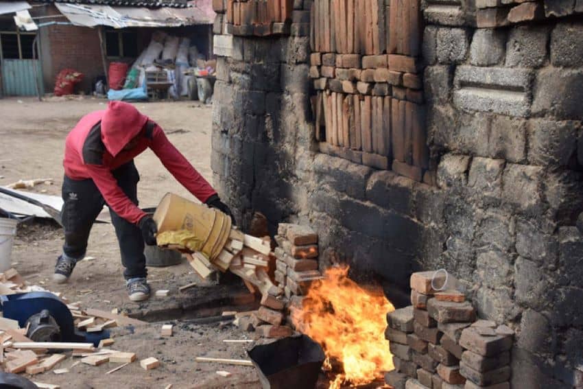 The brick oven requires a mountain of scrap wood as fuel.