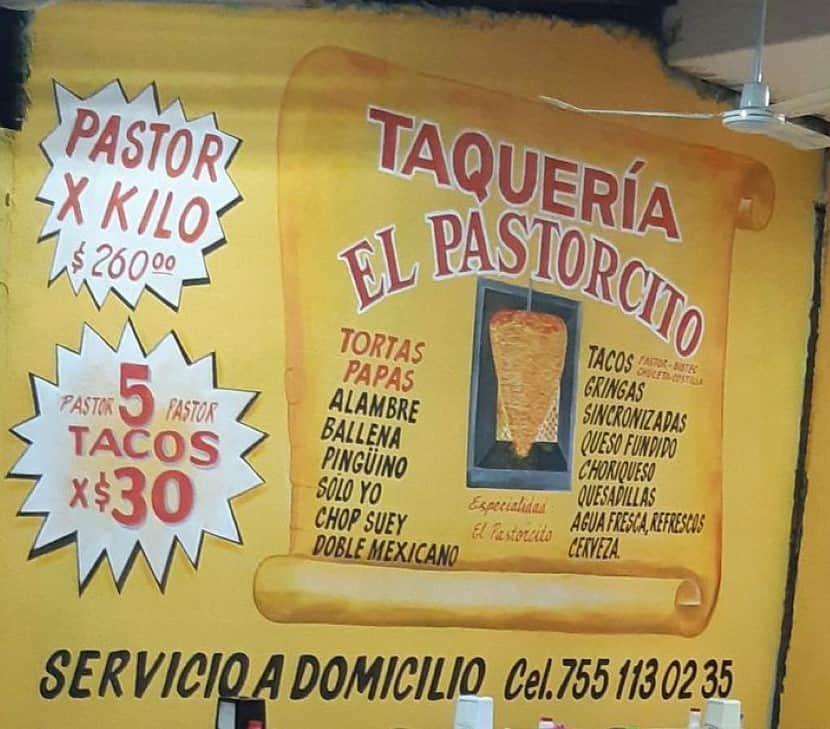 A wall at a neighborhood taquería displays its offerings.