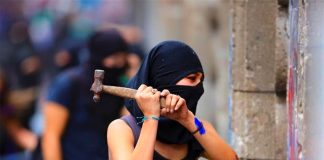 A protester takes a hammer to barricades at the National Palace last week.