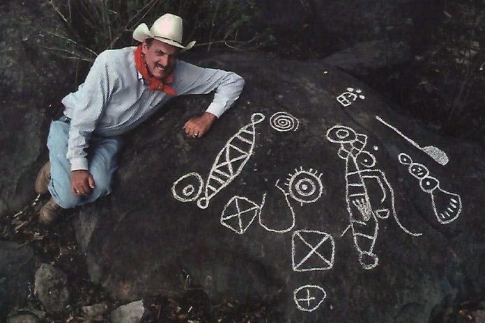 Archaeologist Joseph Mountjoy with examples of Huichol petroglyphs he, with help from National Geographic, documented for exhibit at the Casa Cultura in Mascota.