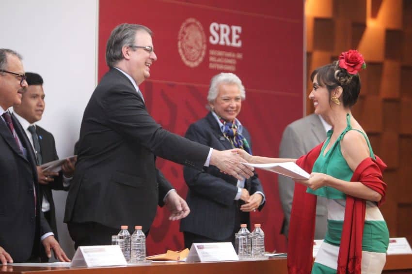 A woman receives her Mexican citizenship papers from Foreign Secretary Marcelo Ebrard and Interior Minister Olga Sánchez Cordero in 2019.
