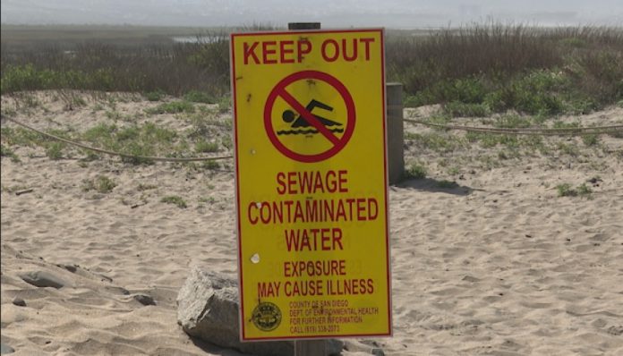 A sign warns Imperial Beach, California residents about water contamination originating from Baja California.