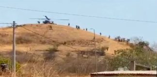 An army helicopter delivers supplies to soldiers camped outside the city of Aguililla.