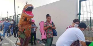 The dinosaur's mom looks decidedly cheerful despite having to wait in line.