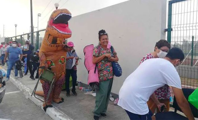 The dinosaur's mom looks decidedly cheerful despite having to wait in line.