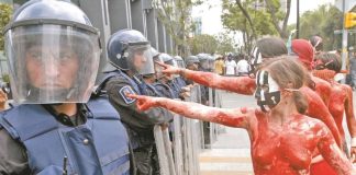 Feminist protesters in an unrelated demonstration face off against the National Guard.