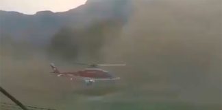 The helicopter amid a huge cloud of dust.