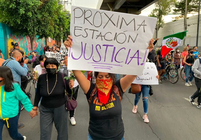 'Next station, justice,' reads the sign of a marcher during a protest Friday