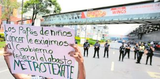 A parent protests the shortage of cancer medications.