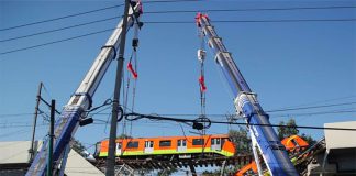 Cranes pick up a Metro carriage after Monday's accident