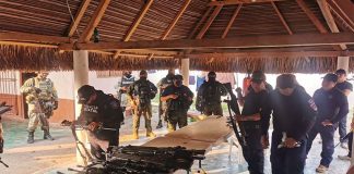 State police inspect weapons seized from local officers.