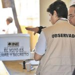 An election observer prepares at a voting station.