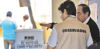 An election observer prepares at a voting station.