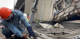 A worker removes debris from the Metro Line 12 accident site.