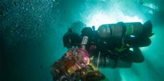 A diver with bags of waste recovered from a cenote.