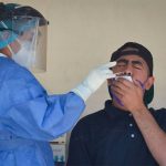 A healthcare worker administers a Covid test.
