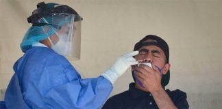 A healthcare worker administers a Covid test.