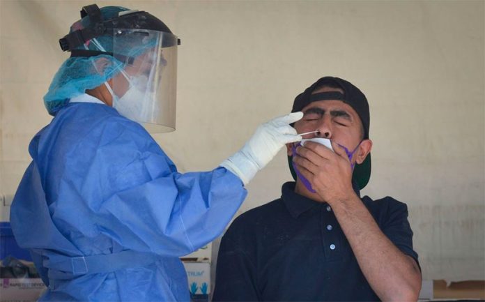 A healthcare worker administers a Covid test.