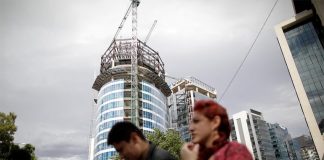 People walk by a building under construction in Mexico City