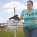 The mother of one of the victims visits his grave.