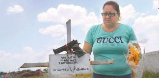 The mother of one of the victims visits his grave.