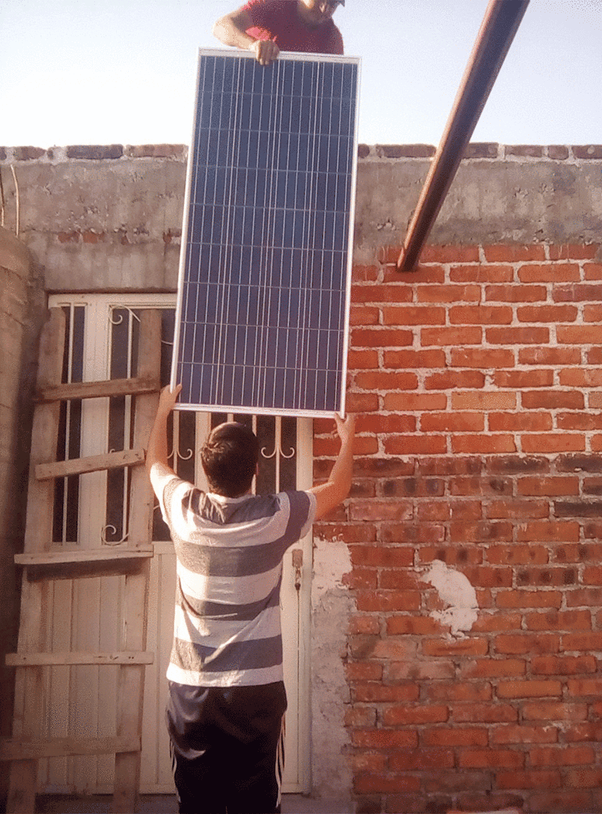 Installing solar panels on a house outside Moroleón, Guanajuato