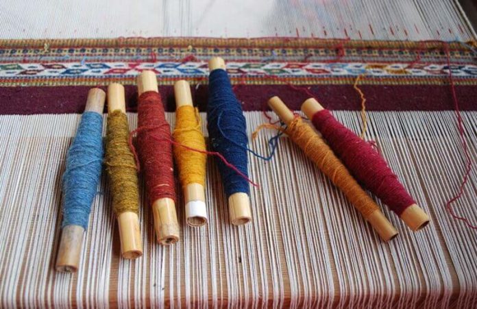 Skeins of yarn colored traditionally with natural dyes ready for weaving
