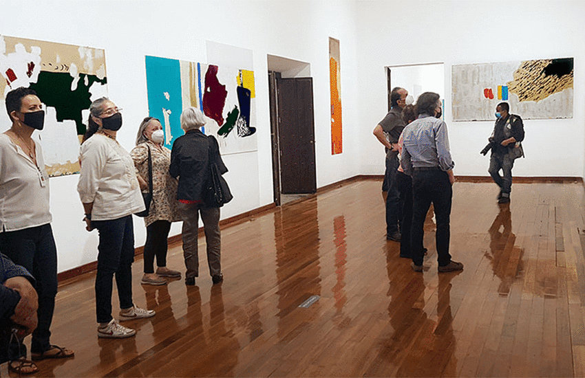 Visitors with paintings by Aníbal Delgado at the Hospicio Cabañas Museum