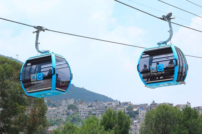 Cablebús cabins carry passengers over Mexico City.