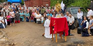 Rev. José Luis Martínez Chávez leads mass next to the place where an armed group destroyed the road, blocking access into town.