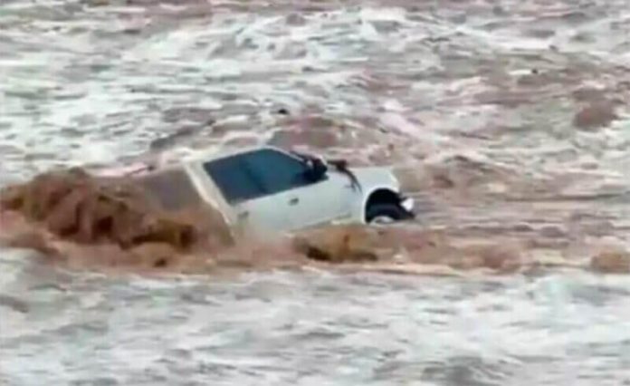 The vehicle from which a woman escaped in a flooded arroyo.
